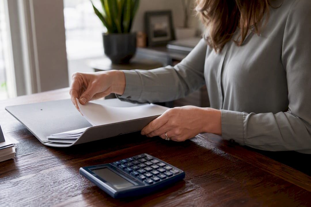 Escrow officer hands with calculator and documents
